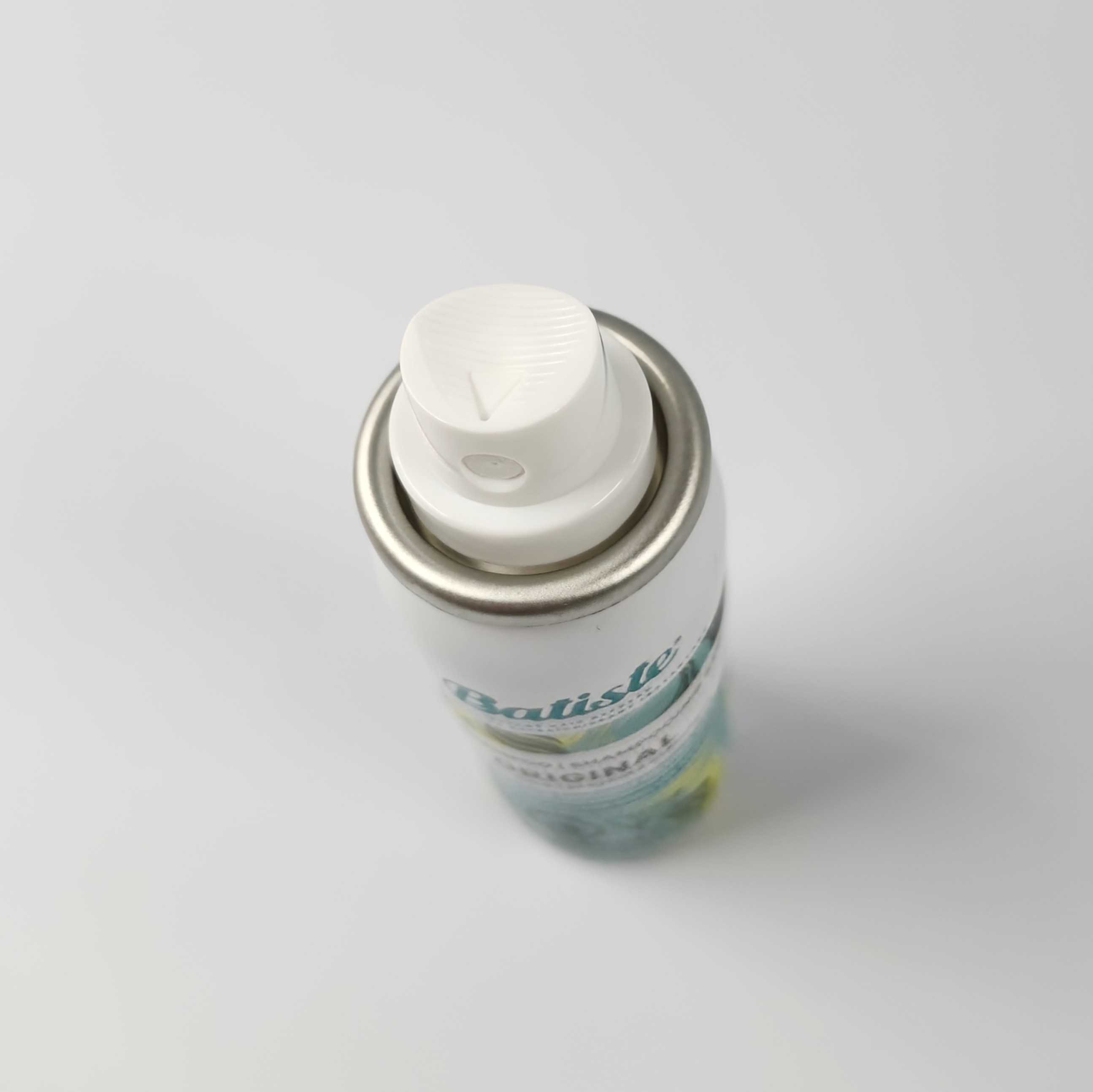 This is the top of the mini dry shampoo bottle. There's slight texture on the top; horizontal lines which creates bumps, and a triangular curve.